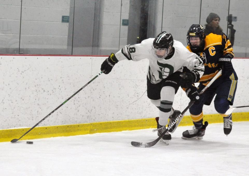 Duxbury's Cormac Weiler,  left, takes control of the puck along the boards as he fends off Hanover's Zach Lee during boys hockey at The Bog in Kingston on Monday, Jan. 31, 2022.