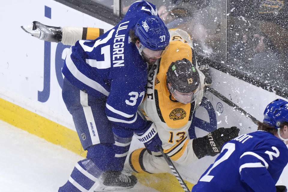 Toronto Maple Leafs defenseman Timothy Liljegren (37) and Boston Bruins center Charlie Coyle (13) crash into the boards in the first period of an NHL hockey game, Thursday, March 7, 2024, in Boston. (AP Photo/Steven Senne)