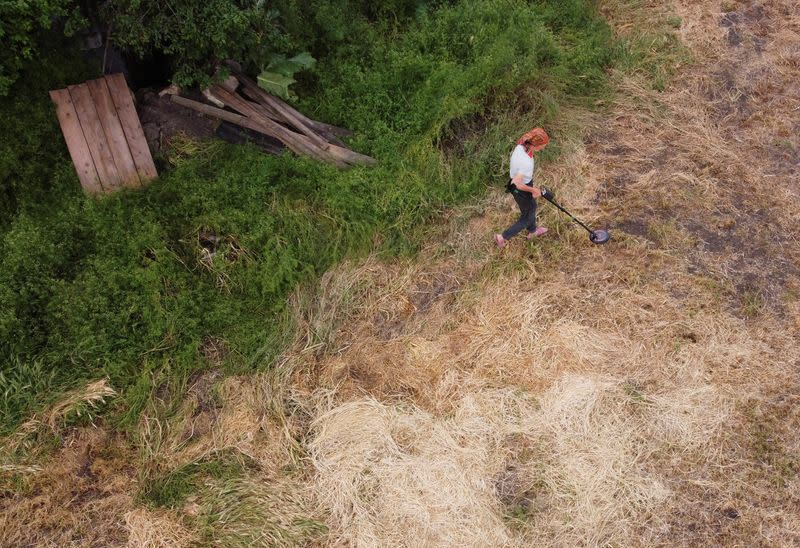 Hanna Plishchynska, 67 años, utiliza un detector de metales para encontrar minas, proyectiles y metralla en un campo cercano a su casa, después de que regresara al pueblo de Stepova Dolyna hace unas semanas, en medio del ataque de Rusia a Ucrania, en la región de Mykolaiv, Ucrania