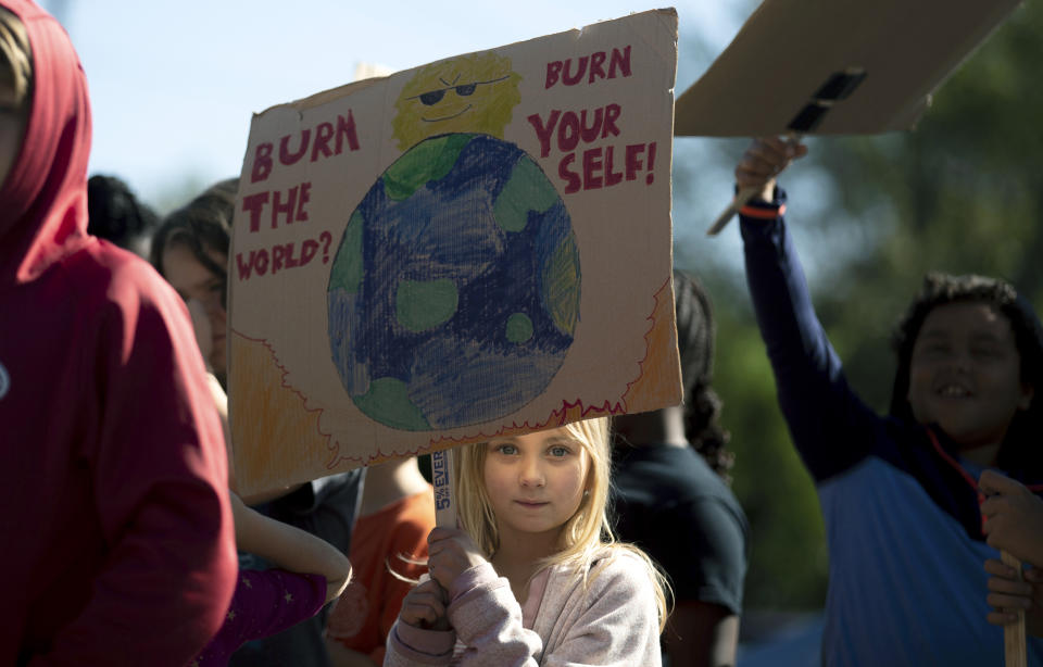 A student holds a sign while participating in a "Global Climate Strike" at the Experiential School of Greensboro in Greensboro, N.C., on Friday, Sept. 20, 2019. Across the globe hundreds of thousands of young people took the streets Friday to demand that leaders tackle climate change in the run-up to a U.N. summit. (Khadejeh Nikouyeh/News & Record via AP)