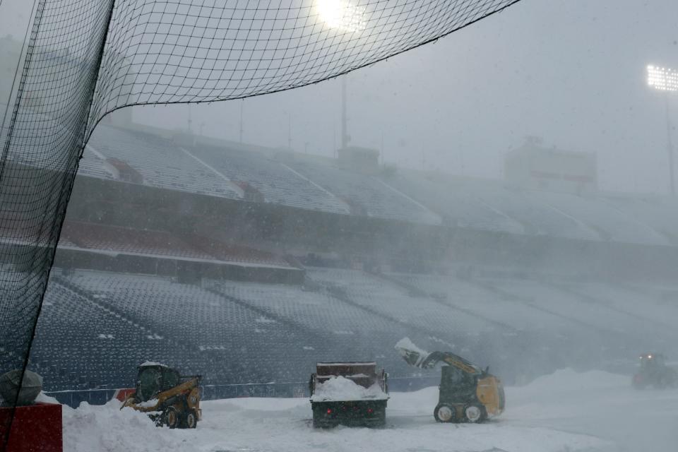 Workers removed snow Sunday from the field, but there was still considerable snow in the seats Monday afternoon.