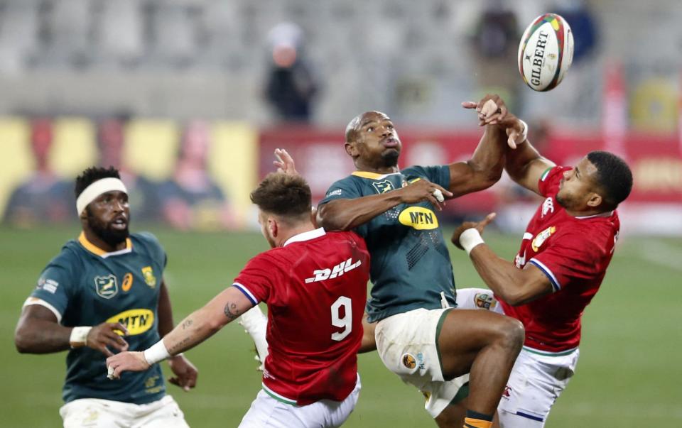South Africa's left wing Makazole Mapimpi (2R) leaps for the ball with British and Irish Lions' scrum-half Ali Price (C) and British and Irish Lions' wing Anthony Watson (R) as South Africa's blindside flanker Siya Kolisi (L) looks on during the first rugby union Test match between South Africa and the British and Irish Lions at The Cape Town Stadium in Cape Town on July 24, 2021. - GETTY IMAGES