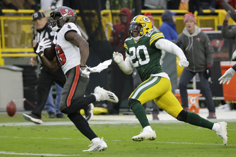 Tampa Bay Buccaneers wide receiver David Moore runs from Green Bay Packers safety Rudy Ford (20) during a 52-yard touchdown reception in the second half of an NFL football game, Sunday, Dec. 17, 2023, in Green Bay, Wis. (AP Photo/Mike Roemer)