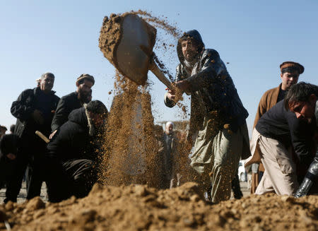 Afghans attend the burial ceremony of a victim who was killed in Tuesday's suicide attack in Kabul, Afghanistan January 11, 2017. REUTERS/Omar Sobhani