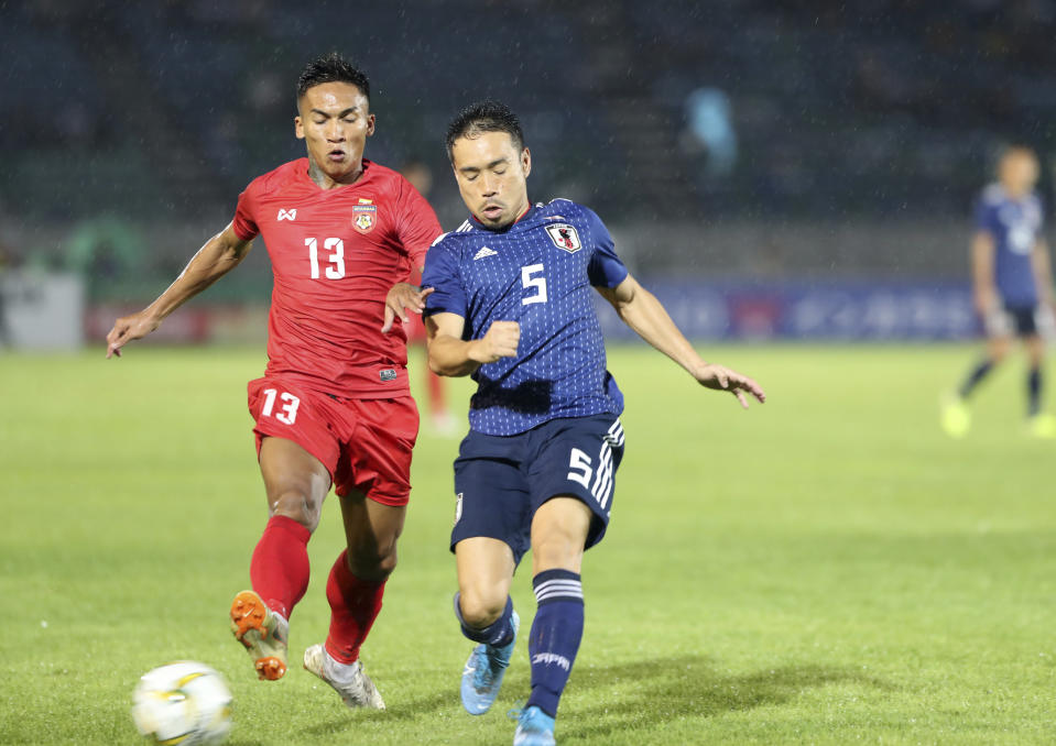 Myanmar's Kaung Sithu, left, vies for the ball with Japan's Auto Nagatomo during their FIFA World Cup 2022 qualifying soccer match at Thuwunna Stadium, Tuesday, Sept. 10, 2019, in Yangon, Myanmar. (AP Photo/Thein Zaw)