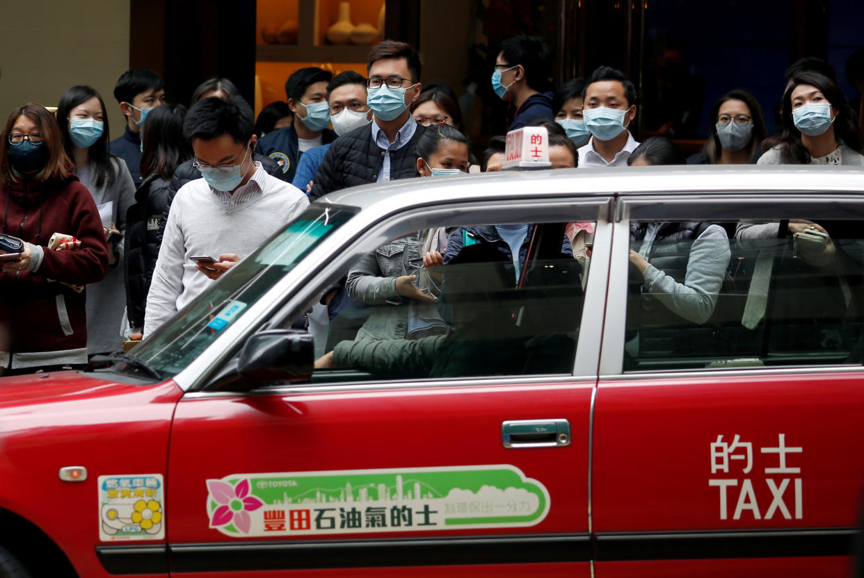 People wear protective masks as they wait to cross the street, following the outbreak of the new coronavirus, in Hong Kong, China February 10, 2020. REUTERS/Tyrone Siu