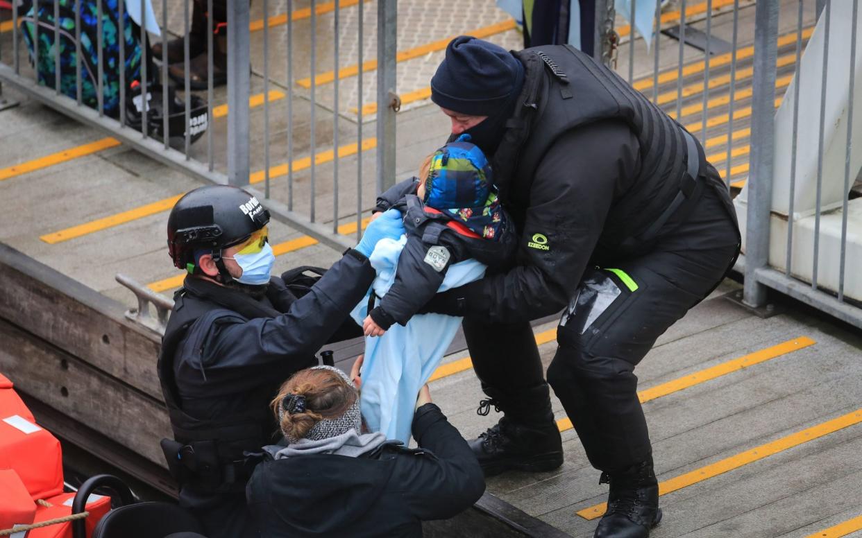 Border Force help a child out of a boat - Gareth Fuller/PA 