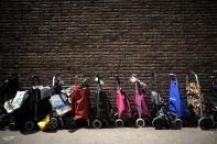 People line up their shopping trolleys as they wait at the entrance of a food distribution center at the Catholic St. William Church in Berlin, Germany, Wednesday, May 31, 2023. German inflation eased to 6.1% in May following several months of declines, even as Europe's biggest economy registered another painful increase in food prices of nearly 15%. (AP Photo/Markus Schreiber)