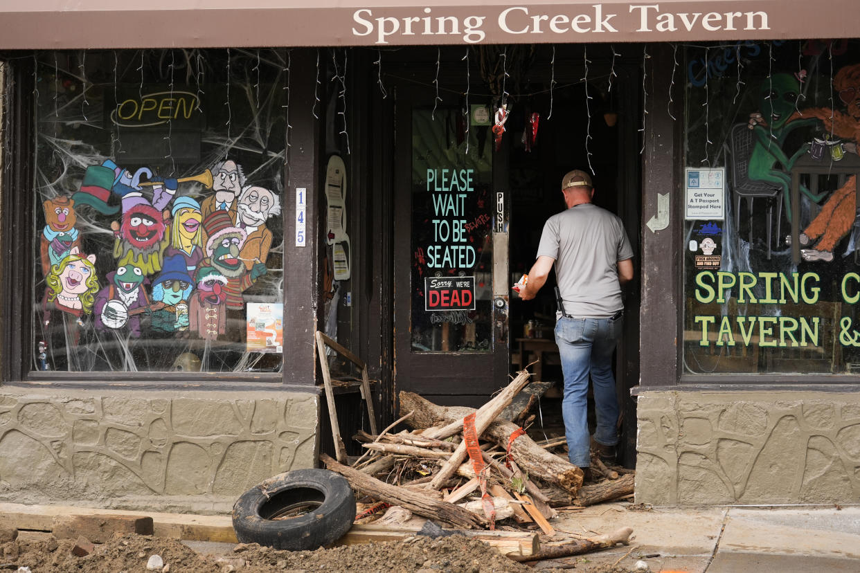 A person enters a heavily damaged building as clean up in the aftermath of Hurricane Helene begins Tuesday, Oct. 1, 2024, in Hot Springs, N.C. (AP Photo/Jeff Roberson)