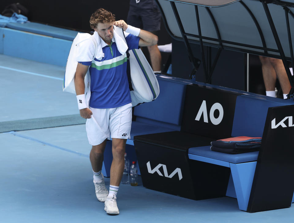 Norway's Casper Ruud walks off the court as he retires in his fourth round match against Russia's Andrey Rublev at the Australian Open tennis championships in Melbourne, Australia, Monday, Feb. 15, 2021. (AP Photo/Hamish Blair)