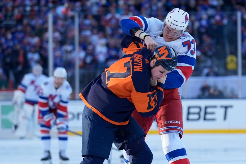 New York Rangers' Matt Rempe, top, fights with New York Islanders' Matt Martin during the first period of an NHL Stadium Series hockey game in East Rutherford, N.J., Sunday, Feb. 18, 2024.