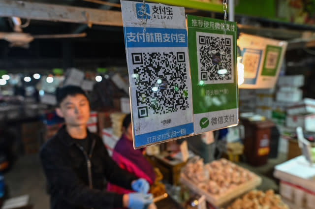 Alipay (L) and Wechat (R) QR payment codes are displayed at a market in Shanghai on October 27, 2020. (Photo by Hector RETAMAL / AFP) (Photo by HECTOR RETAMAL/AFP via Getty Images)