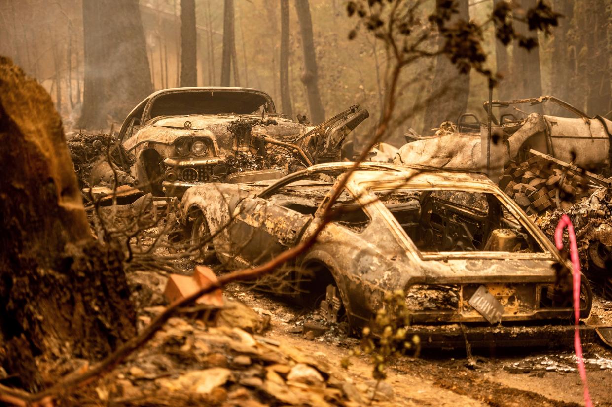 Following the Dixie Fire, scorched vehicles rest in a driveway in the Indian Falls community of Plumas County, Calif., on Monday, July 26, 2021.