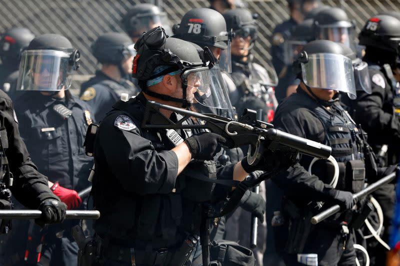 FILE PHOTO: A police officer holds a weapon during nationwide unrest following the death in Minneapolis police custody of George Floyd, in Portland