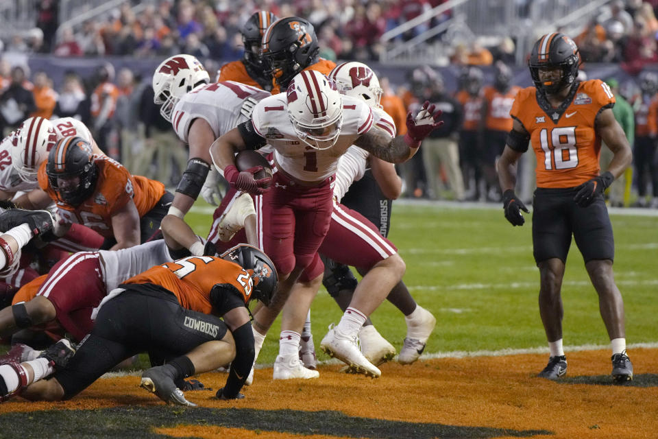 Wisconsin running back Chez Mellusi (1) scores a touchdown against Oklahoma State during the first half of the Guaranteed Rate Bowl NCAA college football game Tuesday, Dec. 27, 2022, in Phoenix. (AP Photo/Rick Scuteri)