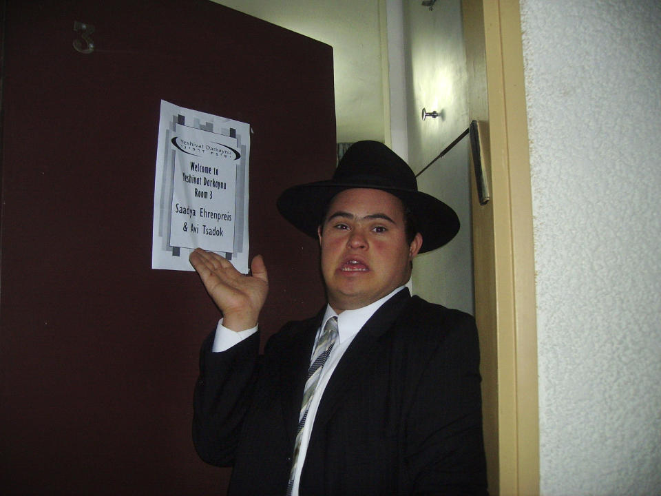 In this Oct. 9, 2006, photo provided by Yaelle Ehrenpreis Meyer, Saadya Ehrenpreis points to the sign displayed on his hotel room door during Yeshivat Darkaynu, a program for special needs young men, in Alon Shvut, Israel. (Yaelle Ehrenpreis Meyer via AP)