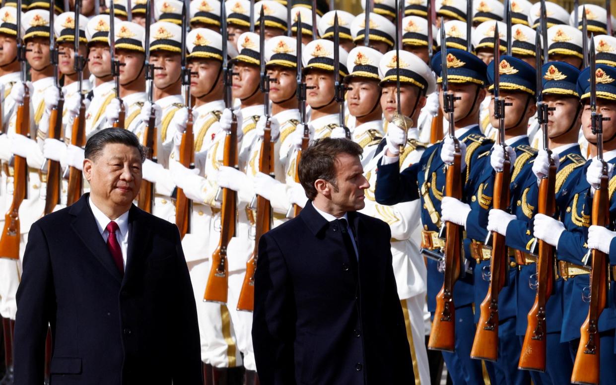 Xi Jinping and French President Emmanuel Macron review troops during an official ceremony