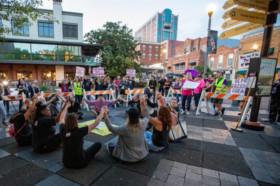 A group of roughly a dozen activists sit in a circle while holding hands to protest SB 300, which would place a ban on abortions after six weeks in Florida. They were later arrested Monday, April 3, 2023.