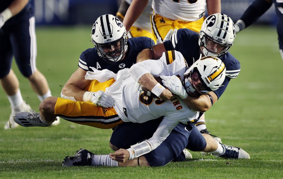 BYU defensive linemen Tyler Batty (92) and John Nelson (94) gang up to sack Wyoming quarterback Andrew Peasley at LaVell Edwards Stadium in Provo on Saturday, Sept. 24, 2022. | Scott G Winterton, Deseret News