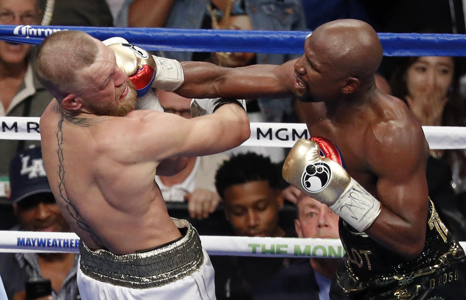 Floyd Mayweather Jr. hits Conor McGregor in a super welterweight boxing match in Las Vegas. (AP)