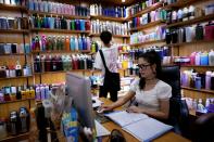 Deng Jinling, manager of Lucky Bird Trade Co. checks her online store on a company at a cup products shop at the Yiwu Wholesale Market following an outbreak of the novel coronavirus disease (COVID-19), in Yiwu