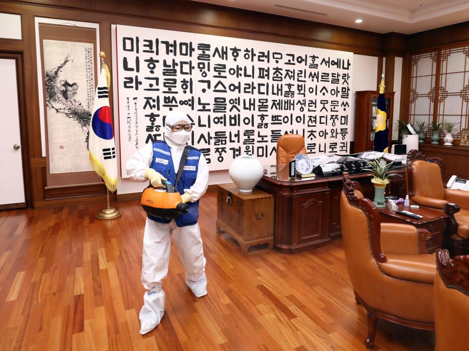 Employees from a disinfection service company sanitize the National Assembly in Seoul, South Korea, February 25, 2020. Yonhap via REUTERS .JPG