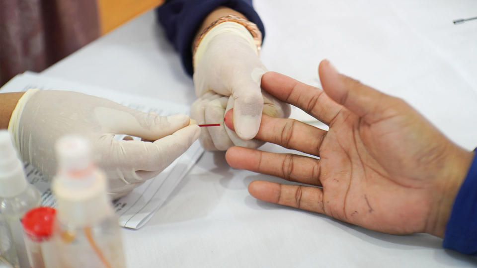 person having a finger prick blood test