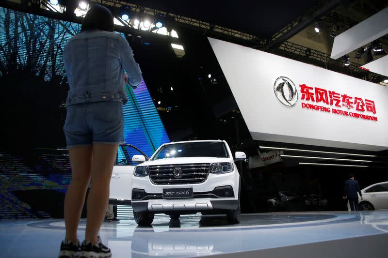 FILE PHOTO: A woman takes picture of Dongfeng Motor Corp SX6 SUV model at the Auto China 2016 auto show in Beijing