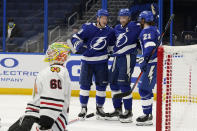 Tampa Bay Lightning left wing Ondrej Palat (18) celebrates with teammates center Steven Stamkos (91) and center Brayden Point (21) after scoring against Chicago Blackhawks goaltender Collin Delia (60) during the second period of an NHL hockey game Friday, Jan. 15, 2021, in Tampa, Fla. (AP Photo/Chris O'Meara)