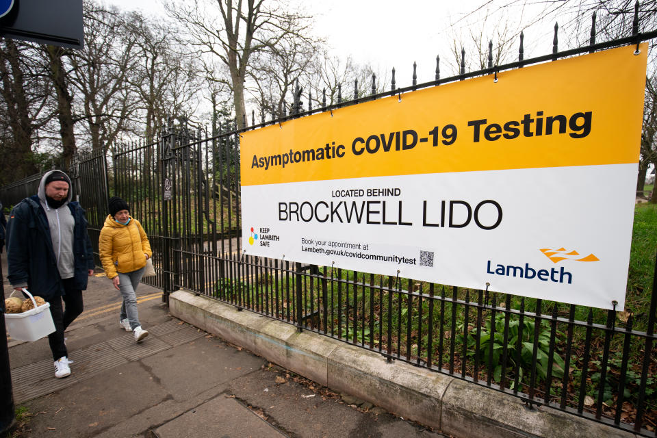 Members of the public walk past an asymptomatic COVID-19 testing centre in Brockwell, London, as the government continues to ramp up the vaccination programme against Covid-19.