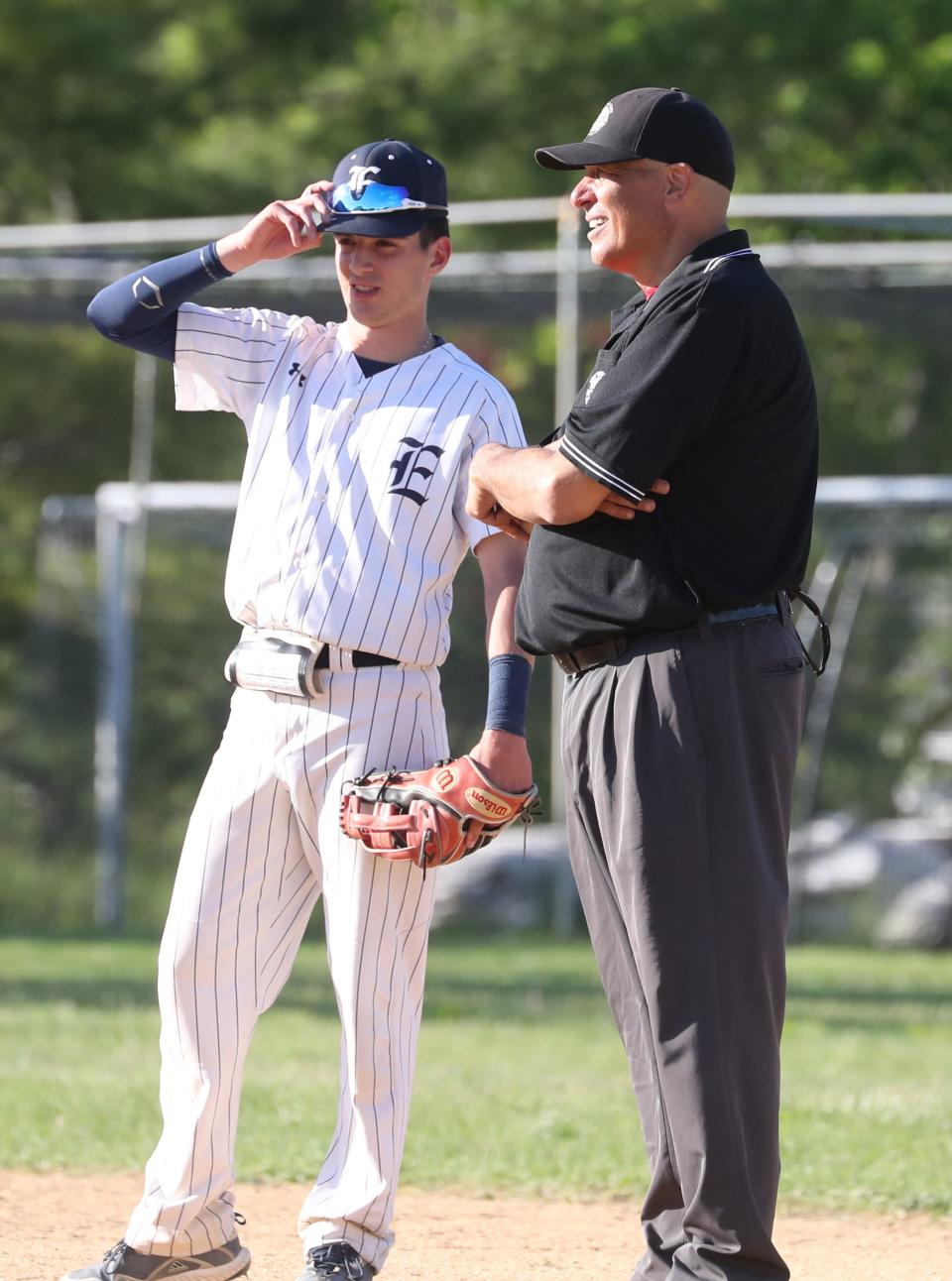 Umpire Lou Gaudio talks with Eastchester's Mike Rinaldi during Class A quarterfinal playoff game at Eastchester May 18, 2022.