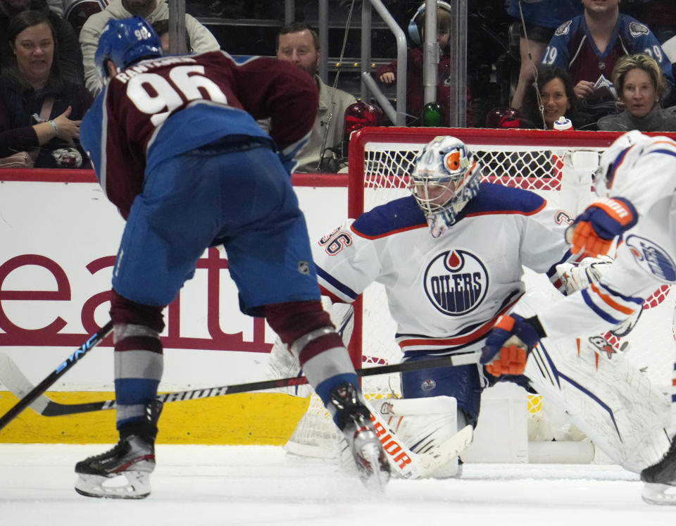 Colorado Avalanche right wing Mikko Rantanen, left, lines up a shot to score the winning goal past Edmonton Oilers goaltender Jack Campbell (36) in overtime of an NHL hockey game Sunday, Feb. 19, 2023, in Denver. (AP Photo/David Zalubowski)