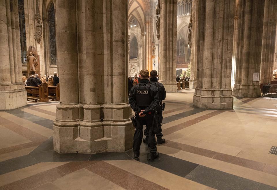 Police officers secure the Cologne Cathedral during the end-of-year pontifical mass in Cologne, Germany, Sunday, Dec. 31, 2023. German authorities say they have detained three more people in connection with a reported threat to Cologne Cathedral over the holiday period. (Thomas Banneyer/dpa via AP)