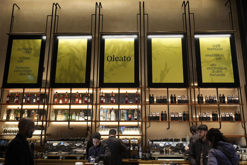 Un letrero anuncia el café Oleato en una cafetería de la cadena Starbucks en Milán, Italia, el lunes 27 de febrero de 2023. Añadir aceite de oliva al café no es una tradición en Italia, pero eso no impidió que Howard Schultz, director general interino de Starbucks, lanzara una serie de bebidas que combinan ambos ingredientes y que actualmente se ofrecen en Milán, la ciudad que inspiró su imperio de cafeterías. (AP Foto/Antonio Calanni)