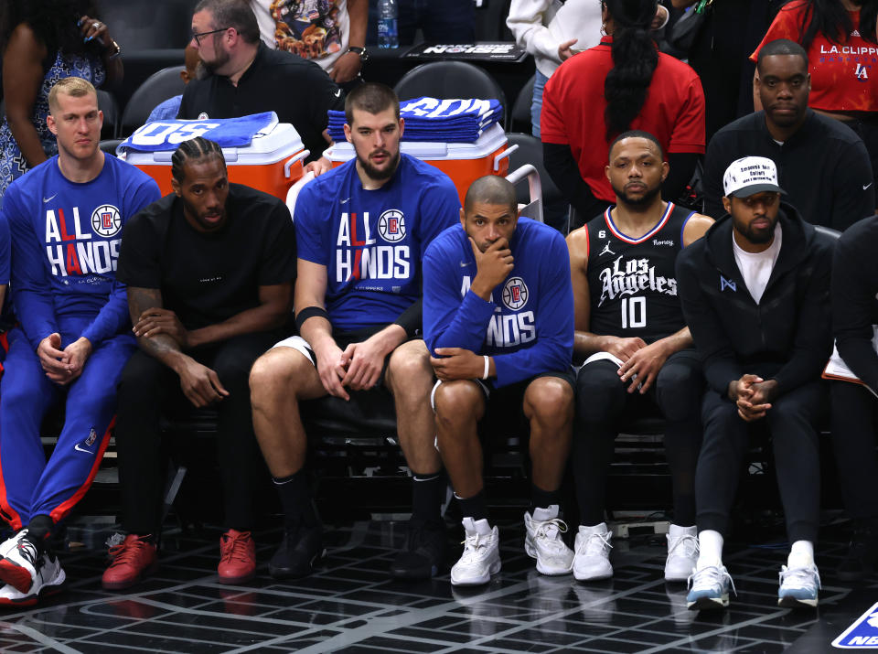 Los Angeles Clippers players, from left, Mason Plumlee, Kawhi Leonard, Ivica Zubac, Nicolas Batum, Eric Gordon and Paul George watch from the bench during Game 4 of their first-round NBA playoffs series against the Phoenix Suns at Crypto.com Arena in Los Angeles on April 22, 2023. (Harry How/Getty Images)