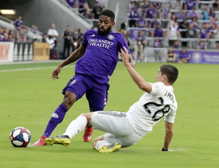 D.C. United's Joseph Mora, right, collides with Orlando City's Ruan, left, going after the ball during the first half of an MLS soccer match, Sunday, March 31, 2019, in Orlando, Fla. Mora was injured in the play and left the match. (AP Photo/John Raoux)