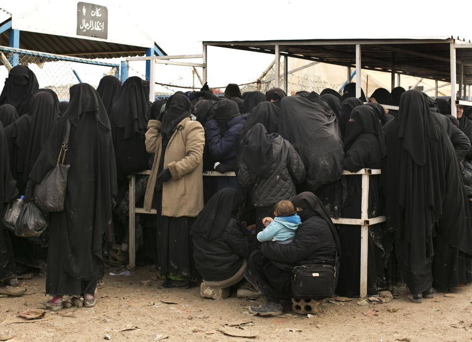 FILE - Women residents from former Islamic State-held areas in Syria line up for aid supplies at Al-Hol camp in Hassakeh province, Syria, March 31, 2019. Syria’s civil war has entered its 14th year on Friday March 15, 2024, a somber anniversary in a long-frozen conflict. The country is effectively carved up into areas controlled by the Damascus government, various opposition groups and Kurdish forces. (AP Photo/Maya Alleruzzo, File)