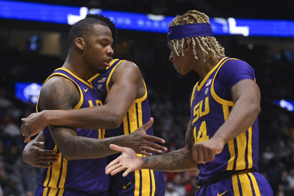 LSU forward KJ Williams, left, is hugged by Shawn Phillips, as Kendal Coleman, right, also celebrates during the second half of an NCAA college basketball game in the first round of the Southeastern Conference tournament, Wednesday, March 8, 2023, in Nashville, Tenn. LSU won 72-67. (AP Photo/John Amis)