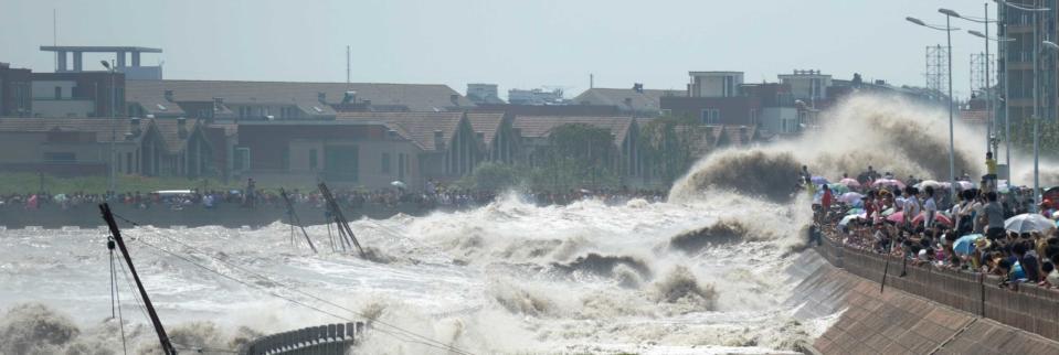 Spectators are swept by huge waves while watching tides of Qiantang River at a dike on August 31, 2011 in Haining, Zhejiang Province of China. 