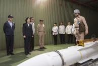 FILE - In this photo Friday, April 13, 2018, file photo, released by Military News Agency, Taiwan's President Tsai Ing-wen, second from left, listens to a brief on a missile at Su'ao naval station during a navy exercise in the northeastern port of Su'ao in Yilan County, Taiwan. Taiwan is responding to China’s defense buildup by developing missiles and interceptors of its own that could reduce Beijing’s military advantage over the island, defense experts say. (Military News Agency via AP, File)