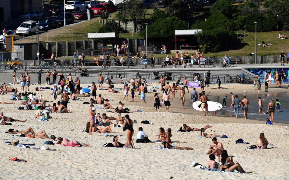 People relaxed at Bondi Beach in Sydney on Wednesday as authorities announced that millions of residents will spend another month in lockdown - SAEED KHAN/AFP