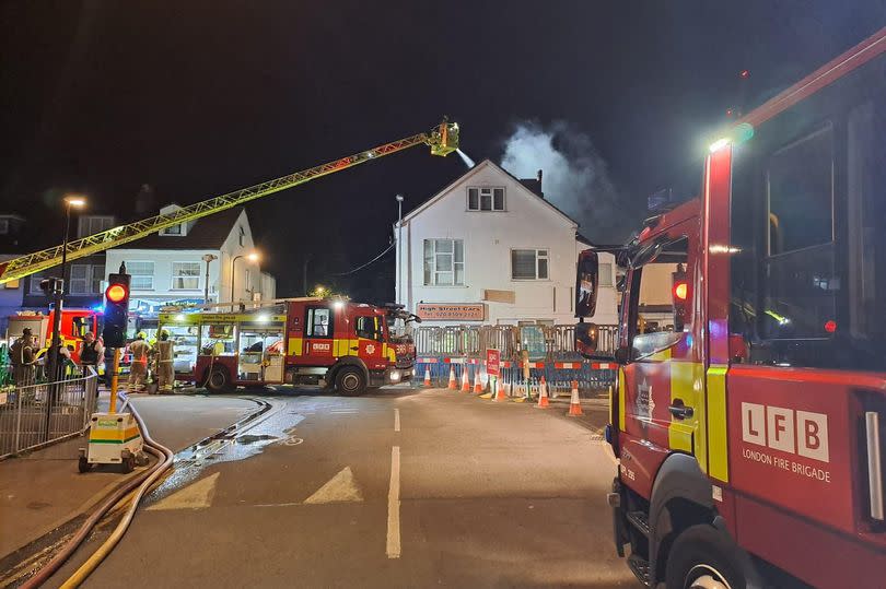 Picture of fire engines at house with smoke coming out of its roof