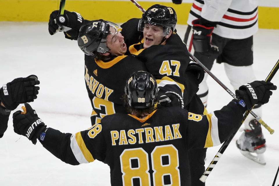 Boston Bruins defenseman Torey Krug (47) celebrates his goal with defenseman Charlie McAvoy (73) and right wing David Pastrnak (88) during the third period of an NHL hockey game against the Chicago Blackhawks, Thursday, Dec. 5, 2019, in Boston. (AP Photo/Elise Amendola)