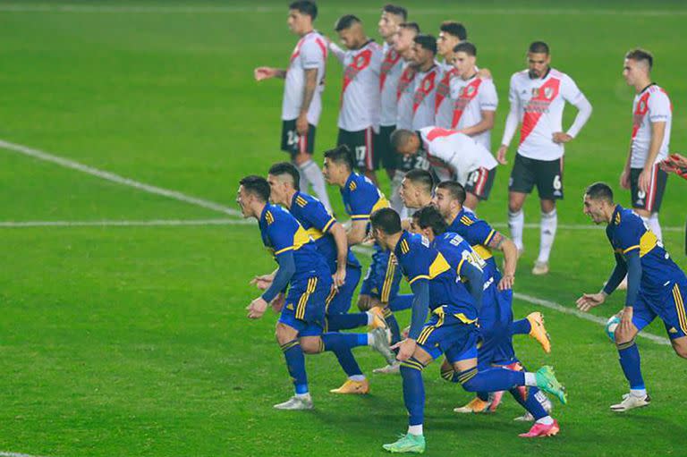 Las dos caras de la definición: los jugadores de Boca corren a abrazar a Carlos Izquierdoz, autor del gol decisivo; los de River lamentan la derrota.