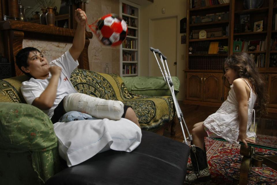 Cierra Abuhamad, 4, is delighted as Abdullah Alathamna plays with a soccer ball