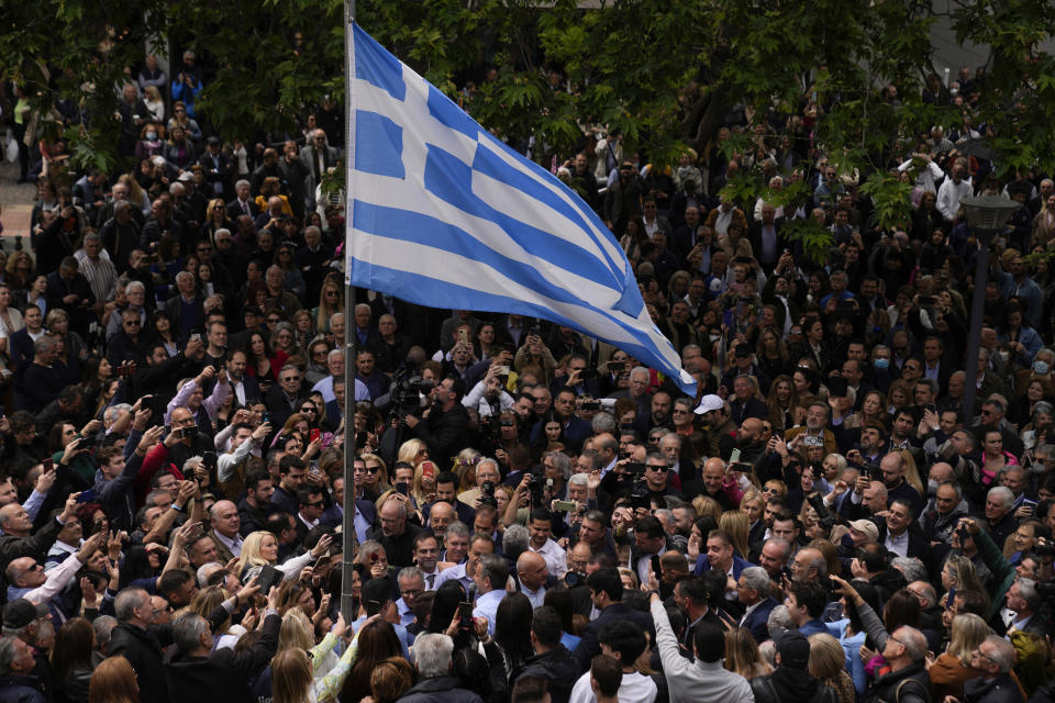 Greece's Prime Minister and New Democracy leader Kyriakos Mitsotakis, center under the Greek flag, speaks to his supporters during his election campaign in northern Athens, Greece, Monday, May 1, 2023. Greeks go to the polls Sunday, May 21, in the first general election held since the country ended successive international bailout programs and strict surveillance period imposed by European leaders. Conservative Prime Minister Kyriakos Mitsotakis is seeking a second four-year term and is leading in opinions but may need a coalition partner to form the next government. (AP Photo/Thanassis Stavrakis)