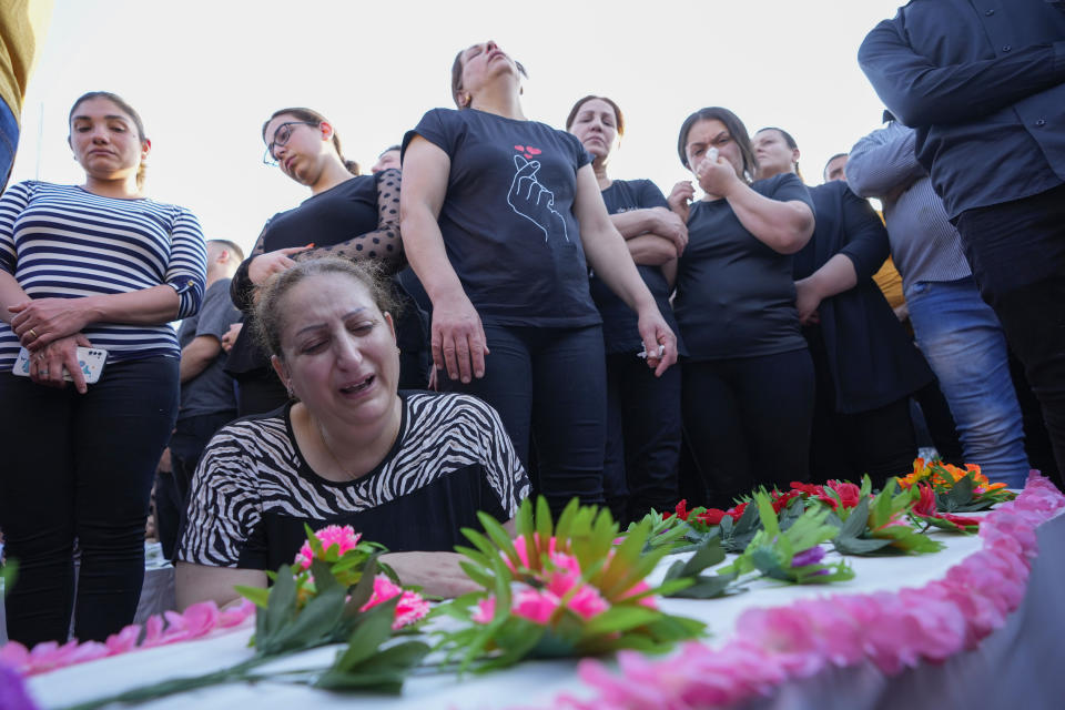 Friends and relatives attend the funeral of people who died in a fire during a wedding ceremony in Hamdaniya, Iraq, Wednesday, Oct. 27, 2023. A fire that raced through a hall hosting a Christian wedding in northern Iraq has killed around 100 people and injured 150 others, and authorities warn the death toll could rise. (AP Photo/Hadi Mizban