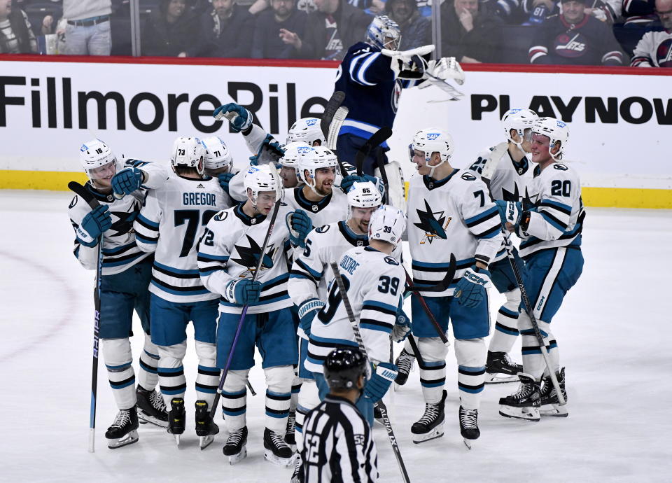 San Jose Sharks celebrate their win over the Winnipeg Jets during an NHL hockey game, in Winnipeg, Manitoba, on Monday March 6, 2023. (Fred Greenslade/The Canadian Press via AP)
