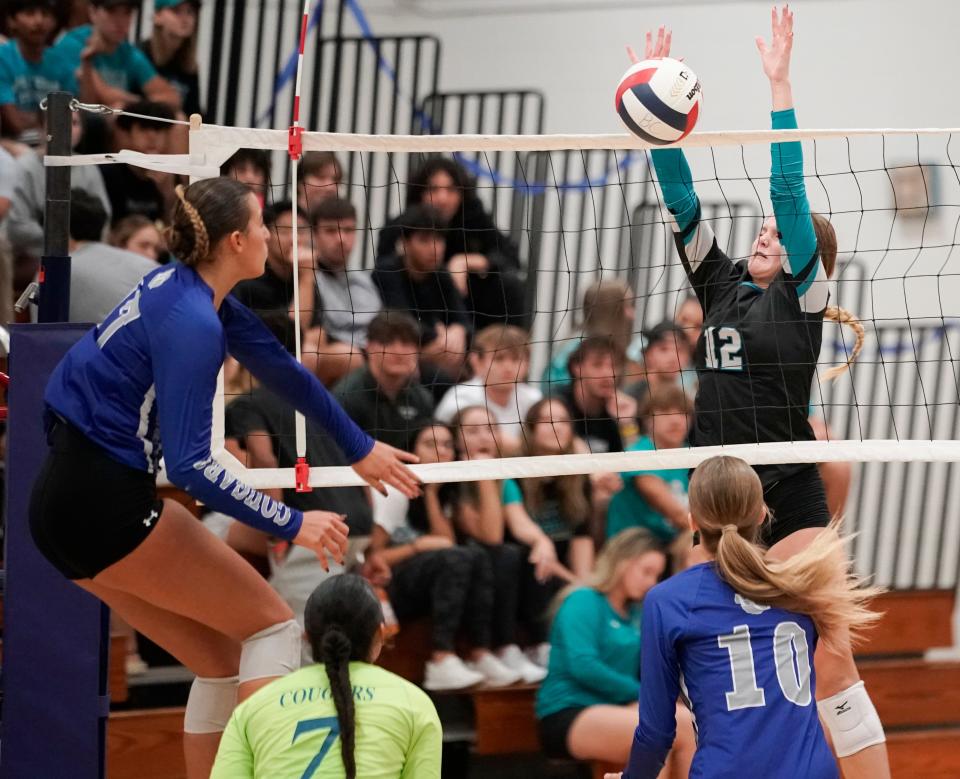 Gulf Coast Sharks opposite hitter Juliette Van Wagner (12) attempts to block a kill attempt from Barron Collier Cougars outside hitter Aisha Keric (17) during the Class 5A Region 3 championship at Barron Collier High School in Naples on Wednesday, Nov. 1, 2023.