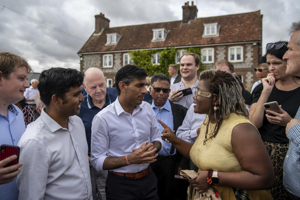 Britain's former Chancellor of the Exchequer Rishi Sunak, centre, speaks to people at an event at Manor Farm, in Ropley, as part of his campaign to be leader of the Conservative Party and the next prime minister, near Winchester, England, Saturday July 30, 2022. (Chris J Ratcliffe/PA via AP)